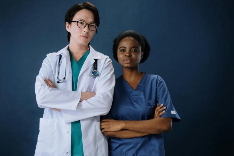 A confident doctor and nurse posing in a studio setting.