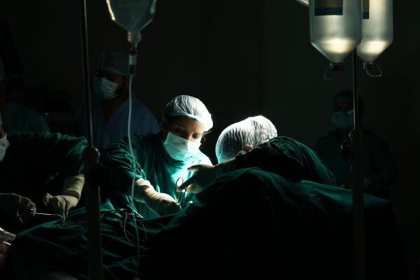 Medical team focused on a critical surgical operation under dim lighting in a hospital.